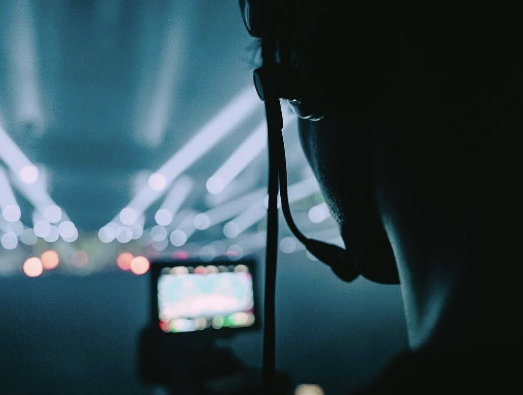 Silhouet van een cameraman bij de monitor in podiumlicht